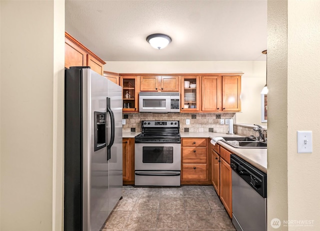 690 32nd St Unit B210, Bellingham, WA 98225 - kitchen featuring appliances with stainless steel finishes, decorative backsplash, light countertops, and brown cabinetry