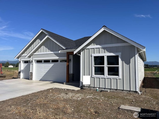 2080 Bowfin Way, Lynden, WA 98264 - view of front of home with board and batten siding, an attached garage, a shingled roof, and concrete driveway