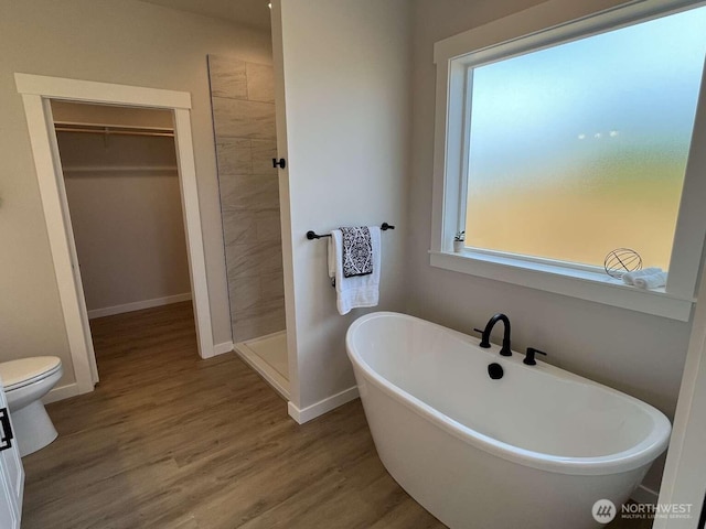 2080 Bowfin Way, Lynden, WA 98264 - bathroom featuring a freestanding bath, a walk in closet, wood finished floors, and a tile shower