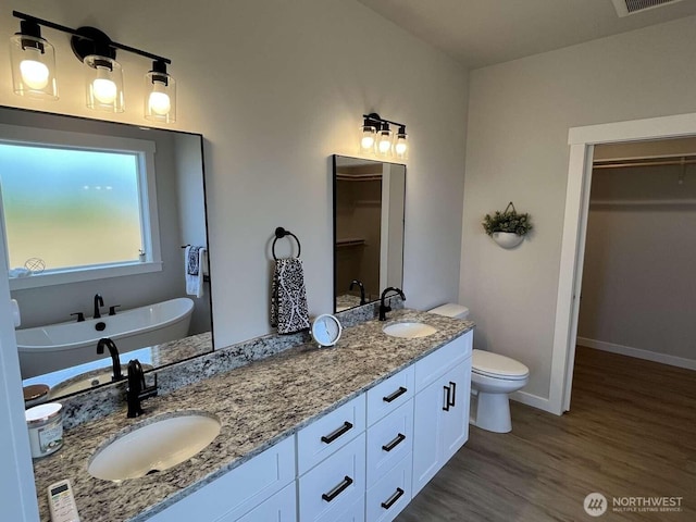2080 Bowfin Way, Lynden, WA 98264 - bathroom with a spacious closet, double vanity, wood finished floors, and a freestanding tub