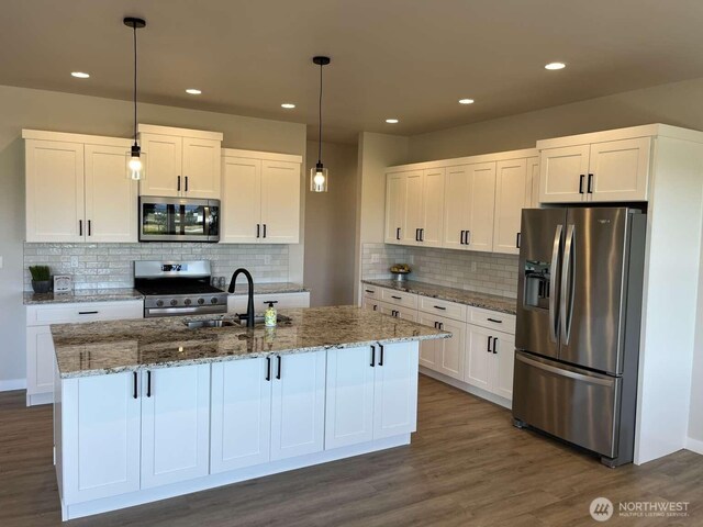 2080 Bowfin Way, Lynden, WA 98264 - kitchen with appliances with stainless steel finishes, white cabinetry, a kitchen island with sink, pendant lighting, and recessed lighting
