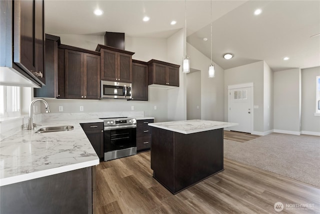 1517 7th Ave NE, Quincy, WA 98848 - kitchen featuring stainless steel appliances, vaulted ceiling, dark brown cabinetry, light countertops, and a center island