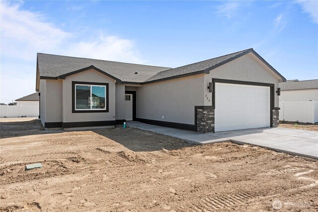 1517 7th Ave NE, Quincy, WA 98848 - ranch-style home with a garage, concrete driveway, a shingled roof, stucco siding, and stone siding