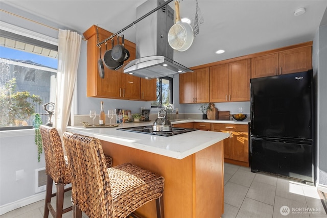 1214 E 61st St, Tacoma, WA 98404 - kitchen with black appliances, island exhaust hood, brown cabinetry, light countertops, and recessed lighting