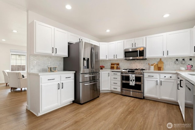 2016 3rd Ct SE, Auburn, WA 98002 - kitchen with appliances with stainless steel finishes, tasteful backsplash, light wood-style flooring, white cabinets, and recessed lighting