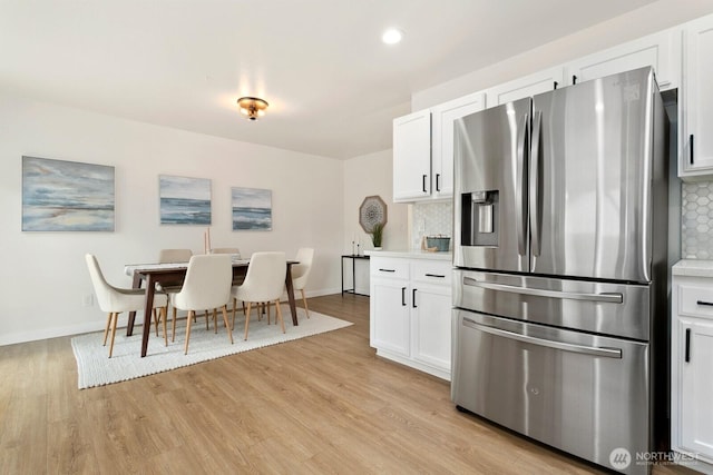 2016 3rd Ct SE, Auburn, WA 98002 - kitchen featuring stainless steel fridge, light wood-style floors, decorative backsplash, white cabinetry, and light countertops