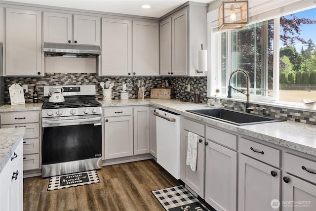 8984 Delta Line Rd, Custer, WA 98240 - kitchen with stainless steel gas stove, exhaust hood, white dishwasher, backsplash, and light countertops