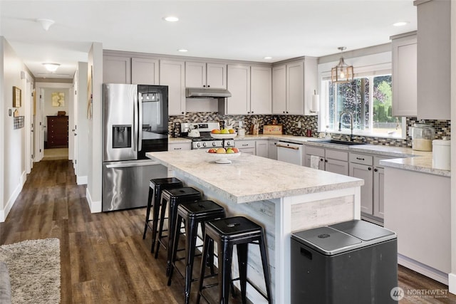 8984 Delta Line Rd, Custer, WA 98240 - kitchen featuring appliances with stainless steel finishes, dark wood-type flooring, light countertops, decorative backsplash, and a kitchen island