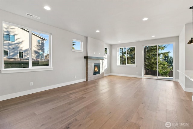 15627LOT15 SE 257th St, Covington, WA 98042 - unfurnished living room with light wood-style floors, a tiled fireplace, and recessed lighting