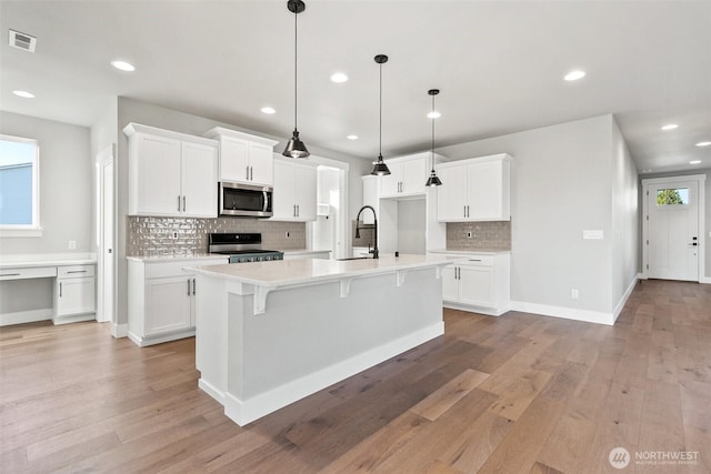 15627LOT15 SE 257th St, Covington, WA 98042 - kitchen with stainless steel appliances, backsplash, light countertops, light wood-style flooring, and recessed lighting