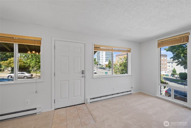 604 N 3rd St Unit 8, Tacoma, WA 98403 - foyer entrance with a baseboard heating unit, plenty of natural light, a textured ceiling, and carpet flooring