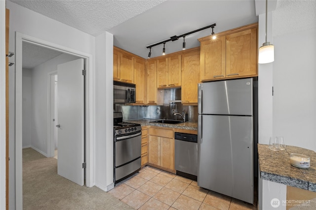 604 N 3rd St Unit 8, Tacoma, WA 98403 - kitchen with appliances with stainless steel finishes, a textured ceiling, rail lighting, backsplash, and light tile patterned flooring