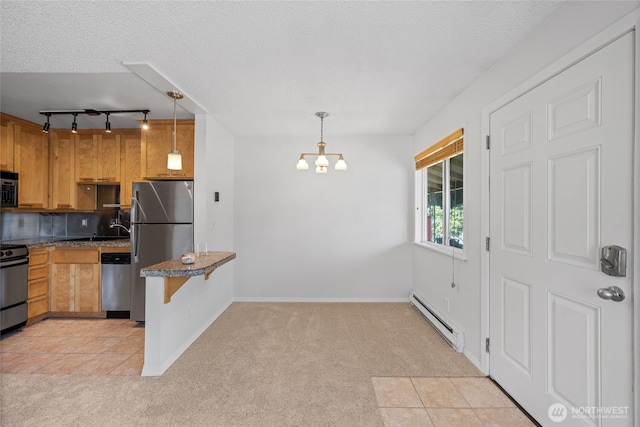 604 N 3rd St Unit 8, Tacoma, WA 98403 - kitchen with light carpet, stainless steel appliances, baseboard heating, rail lighting, and a textured ceiling