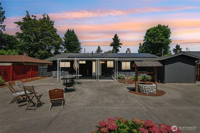 1106 SE 26th St, Auburn, WA 98002 - rear view of property featuring solar panels, a patio area, and a chimney