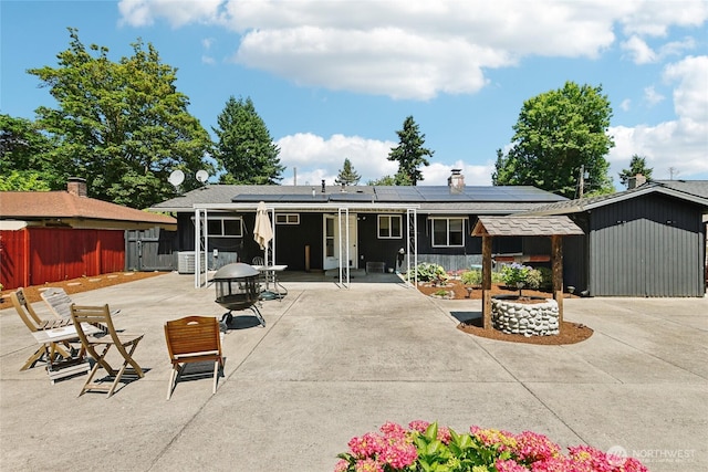 1106 SE 26th St, Auburn, WA 98002 - rear view of property with solar panels, a patio area, and a chimney