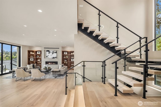 9630 SE 5th St, Bellevue, WA 98004 - staircase with wood finished floors, built in features, recessed lighting, and a large fireplace