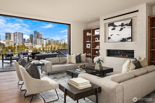 9630 SE 5th St, Bellevue, WA 98004 - living room with a skyline view, wood finished floors, a tiled fireplace, and a wall of windows