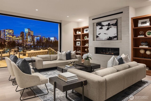 9630 SE 5th St, Bellevue, WA 98004 - living area with wood finished floors, a tiled fireplace, a view of city, and recessed lighting