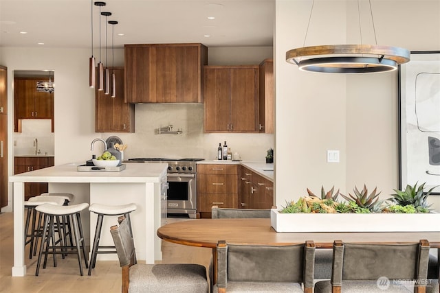 9630 SE 5th St, Bellevue, WA 98004 - kitchen featuring stainless steel range, light countertops, brown cabinetry, light wood finished floors, and recessed lighting