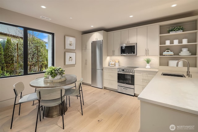 9630 SE 5th St, Bellevue, WA 98004 - kitchen with stainless steel appliances, light countertops, light wood finished floors, open shelves, and recessed lighting