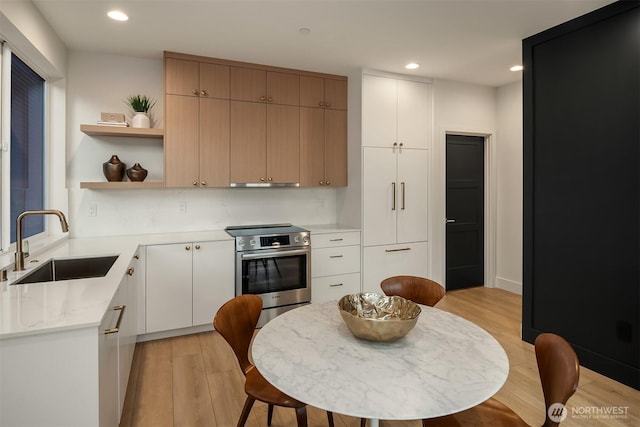 3608 Francis Ave N, Seattle, WA 98103 - kitchen with stainless steel appliances, under cabinet range hood, light wood finished floors, recessed lighting, and open shelves