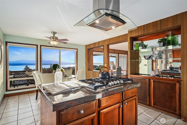 18354 Ridgefield Rd NW, Shoreline, WA 98177 - kitchen with stainless steel gas stovetop, extractor fan, light tile patterned flooring, ceiling fan, and wooden walls