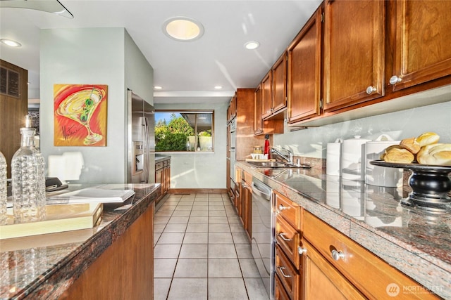 18354 Ridgefield Rd NW, Shoreline, WA 98177 - kitchen with brown cabinetry, dishwasher, light tile patterned flooring, recessed lighting, and dark countertops