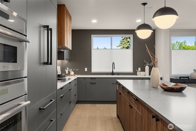 238 4th Ave Unit 300, Kirkland, WA 98033 - kitchen with gray cabinetry, light wood-style flooring, plenty of natural light, decorative backsplash, and recessed lighting