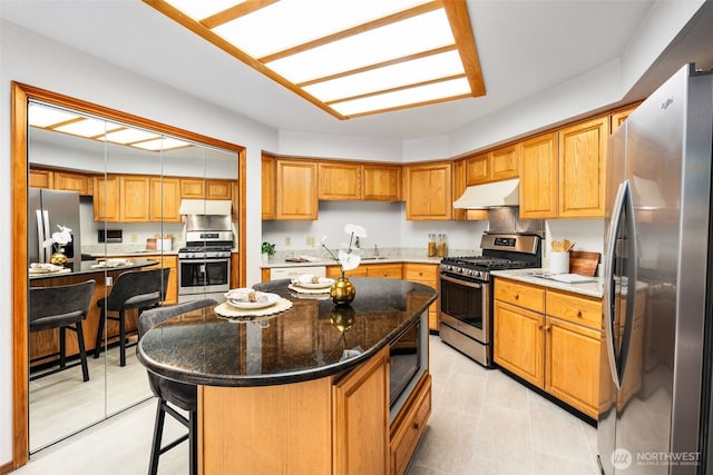33202 2nd Pl SW, Federal Way, WA 98023 - kitchen with stainless steel appliances, under cabinet range hood, a kitchen breakfast bar, and a kitchen island