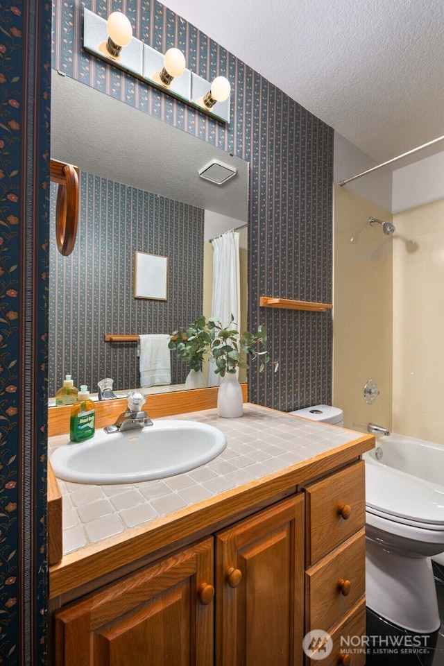 33202 2nd Pl SW, Federal Way, WA 98023 - bathroom featuring wallpapered walls, vanity, a textured ceiling, and shower / tub combo