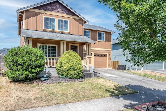 9211 Carys St SE, Yelm, WA 98597 - view of front of home with covered porch, concrete driveway, an attached garage, a front lawn, and board and batten siding