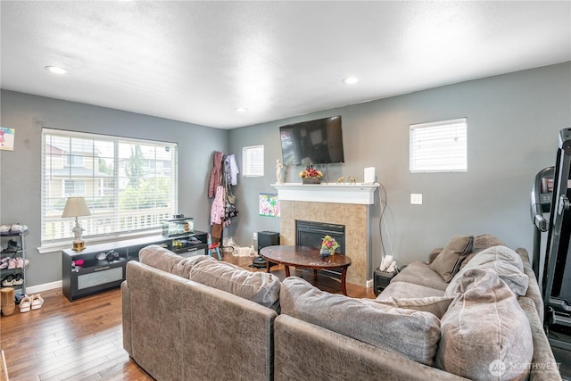 9211 Carys St SE, Yelm, WA 98597 - living room featuring hardwood / wood-style floors, a tiled fireplace, healthy amount of natural light, and recessed lighting