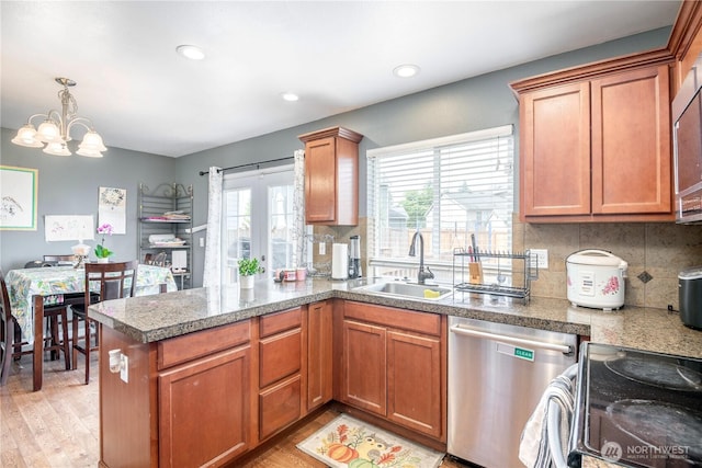 9211 Carys St SE, Yelm, WA 98597 - kitchen featuring stainless steel dishwasher, light wood-style floors, tile countertops, a chandelier, and recessed lighting