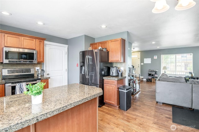 9211 Carys St SE, Yelm, WA 98597 - kitchen with stainless steel appliances, light wood finished floors, open floor plan, recessed lighting, and tasteful backsplash