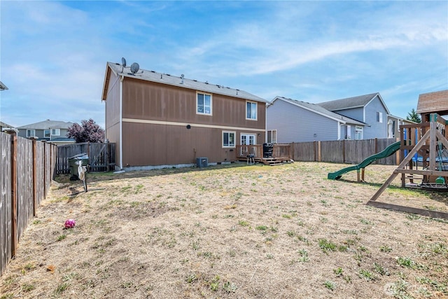 9211 Carys St SE, Yelm, WA 98597 - back of house with a playground, a fenced backyard, and a wooden deck