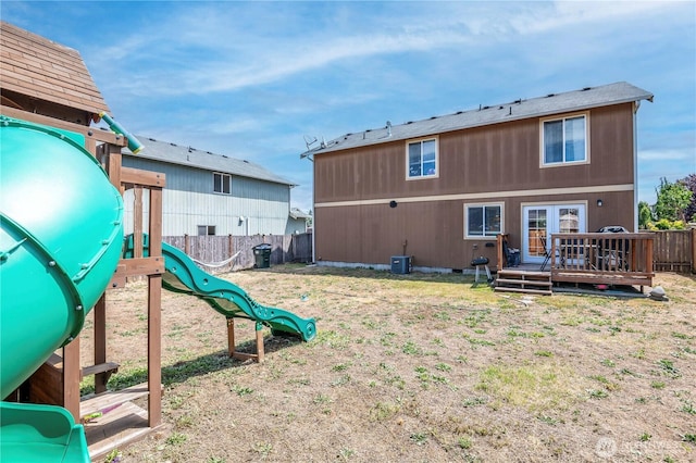 9211 Carys St SE, Yelm, WA 98597 - rear view of property featuring a fenced backyard, a playground, a deck, and french doors