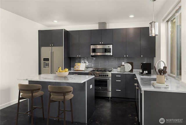 933 16th Avene, Seattle, WA 98122 - kitchen with high end appliances, a breakfast bar, backsplash, pendant lighting, and a kitchen island