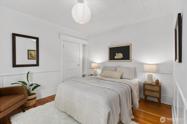 5825 4th Ave NW, Seattle, WA 98107 - bedroom featuring ornamental molding, wood finished floors, and a wainscoted wall