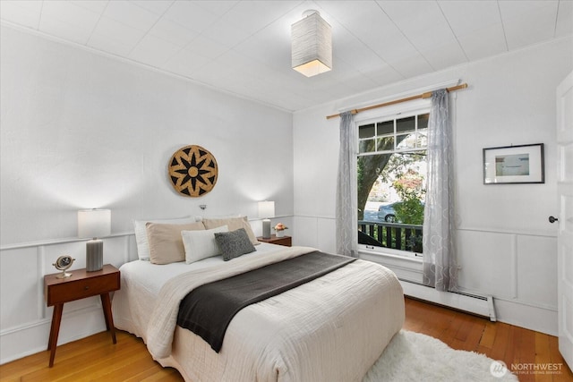 5825 4th Ave NW, Seattle, WA 98107 - bedroom featuring baseboard heating, wood finished floors, and ornamental molding