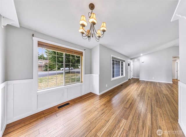 3919 Timothy Ct, Bellingham, WA 98226 - unfurnished living room featuring hardwood / wood-style flooring, a wainscoted wall, a chandelier, and vaulted ceiling