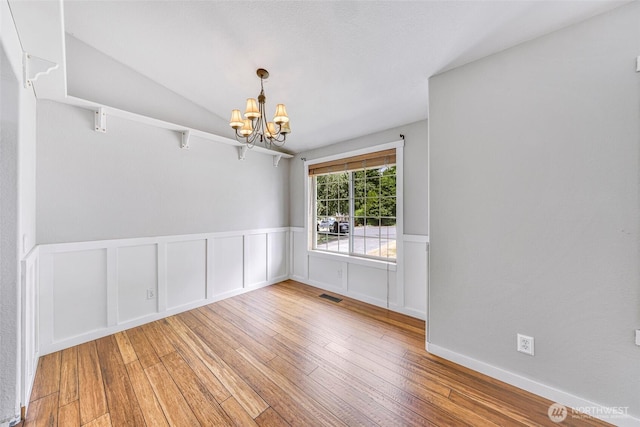 3919 Timothy Ct, Bellingham, WA 98226 - spare room featuring a chandelier, hardwood / wood-style flooring, wainscoting, and vaulted ceiling