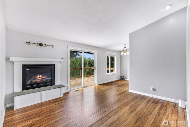 3919 Timothy Ct, Bellingham, WA 98226 - unfurnished living room featuring a chandelier, a glass covered fireplace, and hardwood / wood-style floors