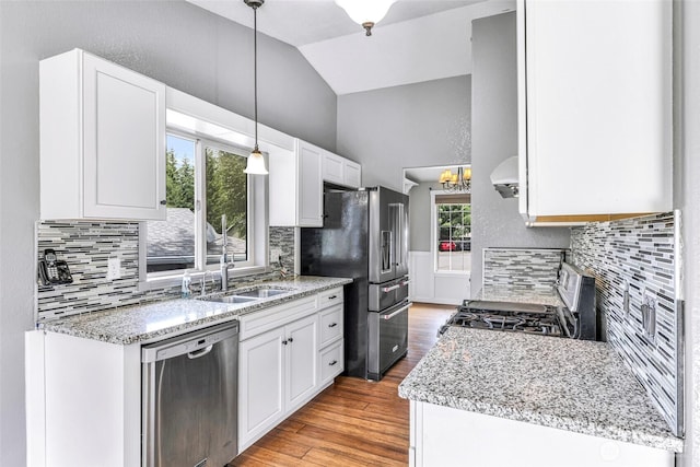 3919 Timothy Ct, Bellingham, WA 98226 - kitchen with stainless steel appliances, decorative backsplash, vaulted ceiling, white cabinets, and wall chimney exhaust hood
