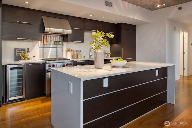 2911 2nd Ave Unit 1120, Seattle, WA 98121 - kitchen featuring wine cooler, exhaust hood, light wood finished floors, modern cabinets, and light countertops