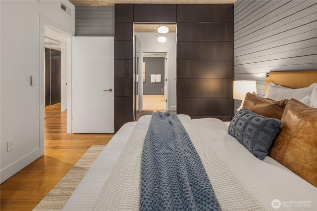 2911 2nd Ave Unit 1120, Seattle, WA 98121 - bedroom with light wood-style flooring and wood walls