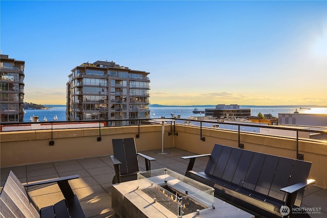 2911 2nd Ave Unit 1120, Seattle, WA 98121 - patio terrace at dusk featuring a water view and an outdoor fire pit
