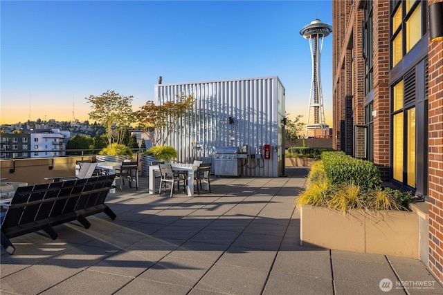 2911 2nd Ave Unit 1120, Seattle, WA 98121 - patio terrace at dusk with outdoor dining area, a patio, and a grill