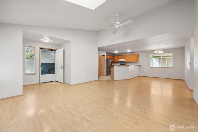 1726 Ann St NE, Olympia, WA 98506 - unfurnished living room featuring light wood-style flooring, a ceiling fan, a skylight, and lofted ceiling