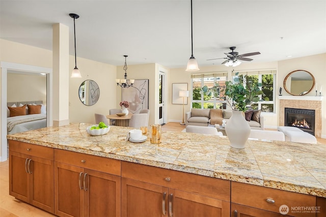 1840 25th Ave NE Unit 210, Issaquah, WA 98029 - kitchen featuring tile counters, open floor plan, brown cabinetry, and a ceiling fan