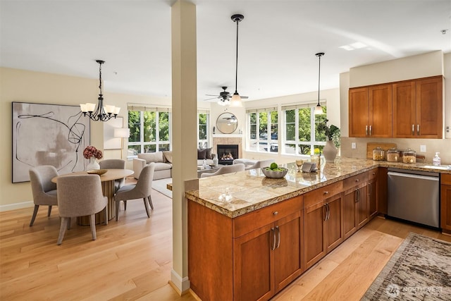 1840 25th Ave NE Unit 210, Issaquah, WA 98029 - kitchen with dishwasher, tile counters, a lit fireplace, brown cabinetry, and ceiling fan